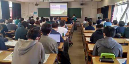 「知の広場（国際化対応）」の講義で工学部社会建設工学科卒業生の吉田健一氏による講演会を開催しました。